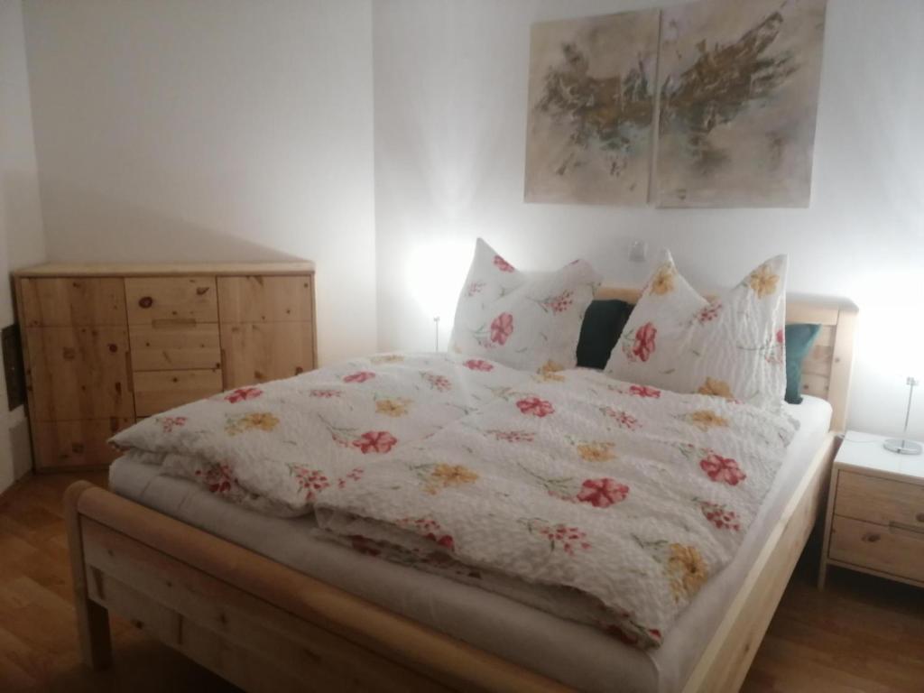 een slaapkamer met een bed met een bloemenbed en kussens bij Appartement Irmi in Söll