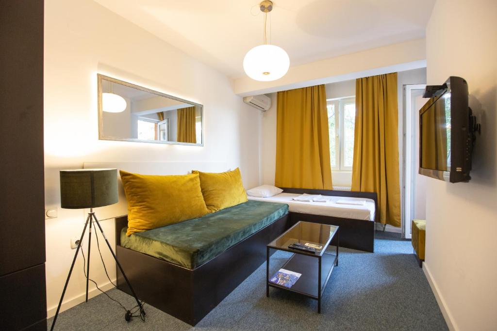 a living room with a couch and a tv at 4 Rooms Apartments,free garage parking for motorcycles in Niš