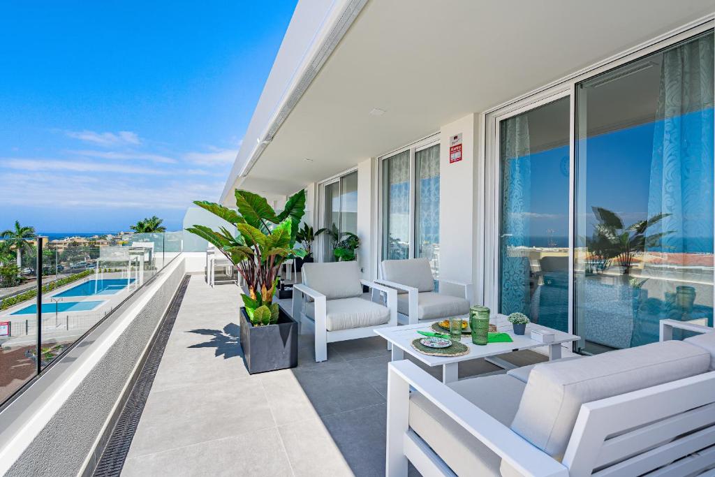 a balcony with white furniture and a view of the ocean at Luxury apartment. Heated Pool. AC. Ocean view! in Adeje