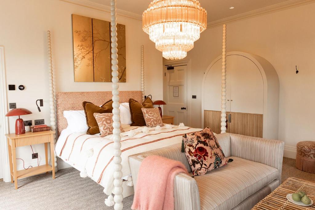 1 dormitorio con cama blanca con dosel y sofá en The Beacon, en Royal Tunbridge Wells