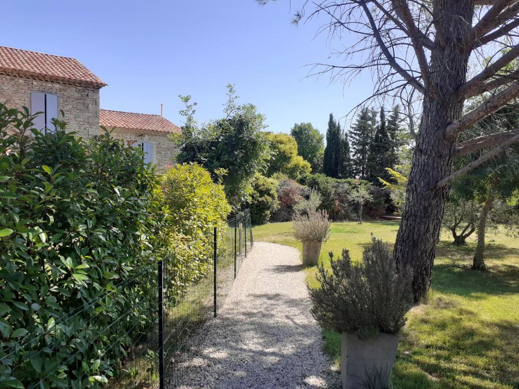 un jardin avec une clôture et un arbre dans l'établissement Cuisine, chambres et salle de bains indépendants, à Saint-Christol-lès-Alès