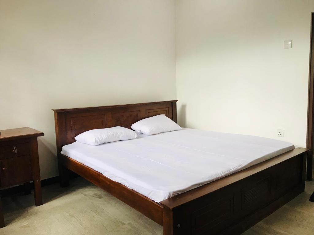 un letto con due cuscini sopra in una stanza di Sinharaja Cave Resort 