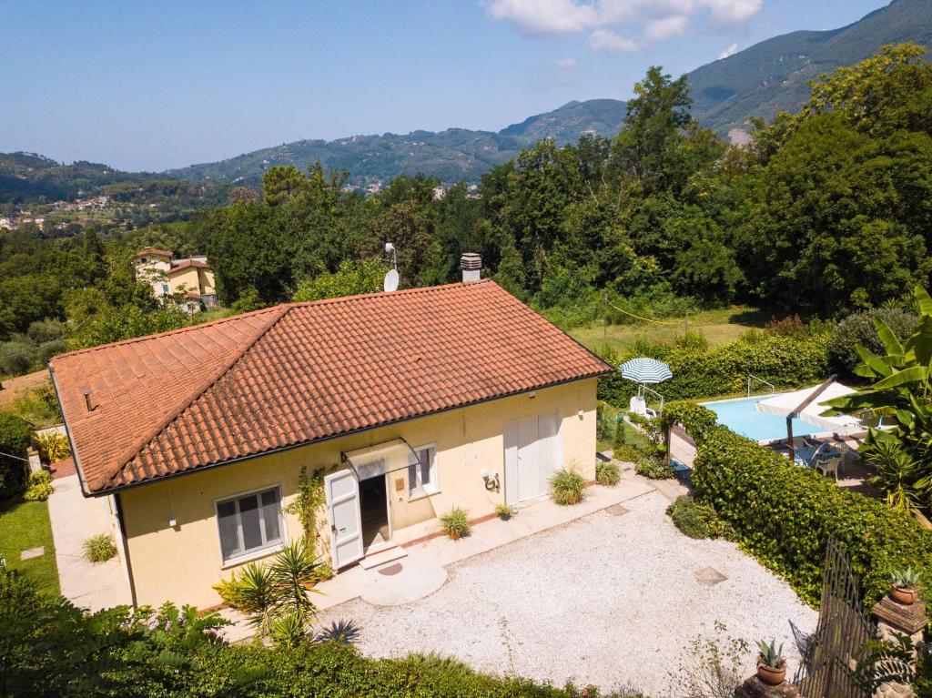 una casa con techo de tejas y piscina en Villino le Farfalle by VacaVilla, en Camaiore