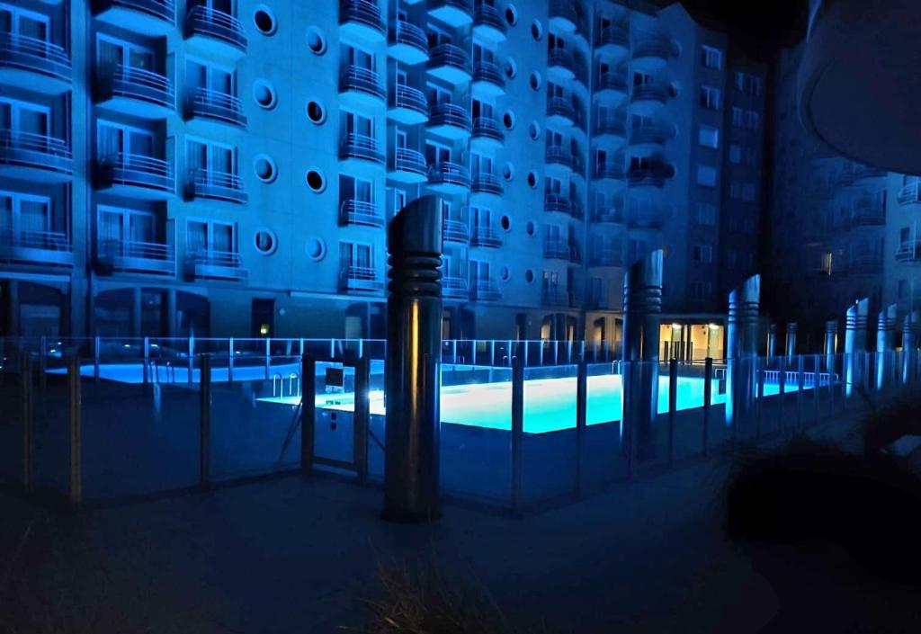 a swimming pool in front of a building at night at Sea-LeVel in Ostend