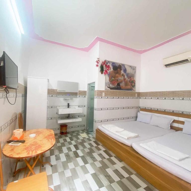 a small room with a bed and a table at Khách sạn Sơn Hà in Can Tho