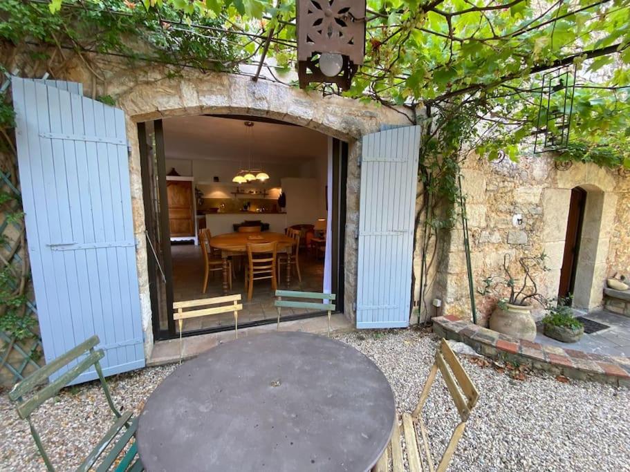 a patio with a table and a dining room at 06AW - Mas en pierre provençal rénové au calme in Le Rouret