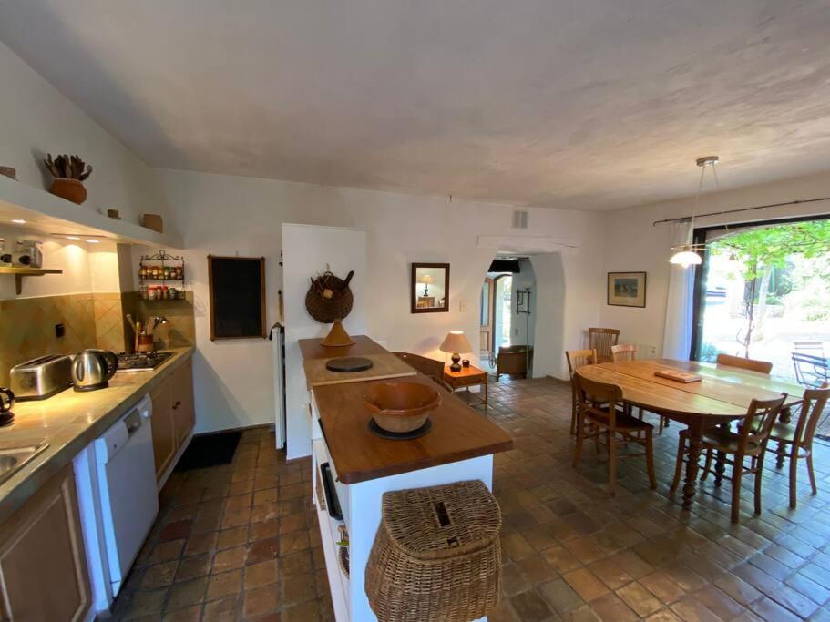 a kitchen and living room with a table and a dining room at 06AW - Mas en pierre provençal rénové au calme in Le Rouret