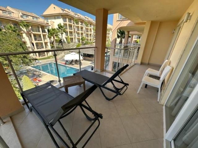 een balkon met een tafel en stoelen en een zwembad bij 3 Bed Duplex Apartment in Soke