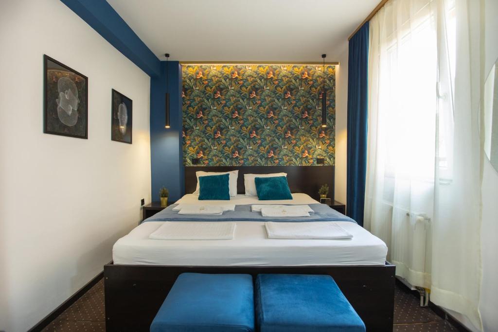 a bedroom with a large bed with blue pillows at 4 Rooms Apartments in Niš