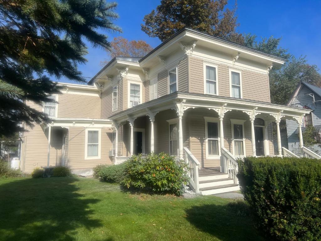 een groot wit huis met een veranda en zuilen bij Doyle House - Near Cooperstown Dreams Park 2 in Milford