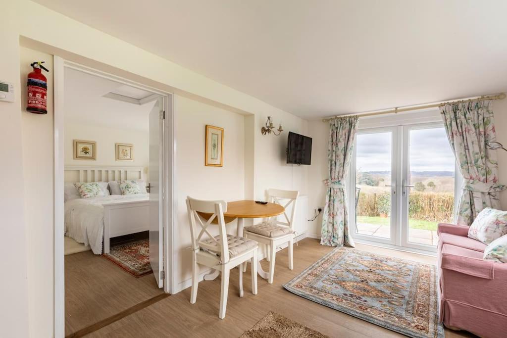 Habitación con mesa, cama y ventana en Oak Tree Cottage, en Uckfield