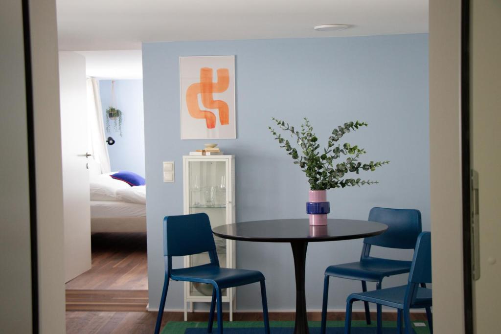 a dining room with a table and blue chairs at Gemütliches City Apartment im Zentrum von Dornbirn, Barcelona 4 in Dornbirn