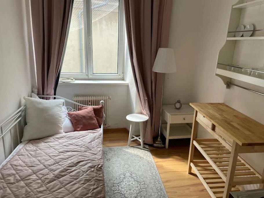 een kleine slaapkamer met een bed en een raam bij Graz City Centre Apartment in Graz