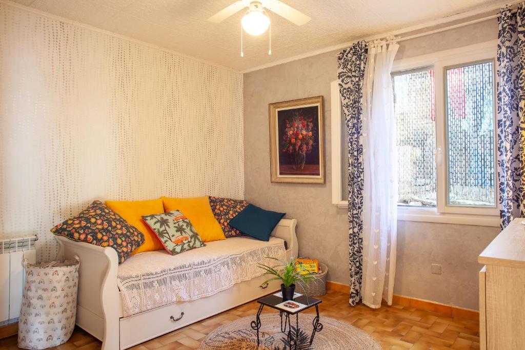 Le Revest-le-EauxにあるLa Figounetteのソファと窓のあるリビングルーム