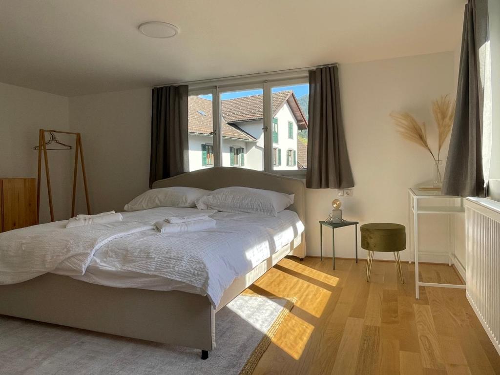 a bedroom with a large bed and a large window at Zentral und Gemütlich, Ihr Dornbirn Zuhause - Paris 7 in Dornbirn