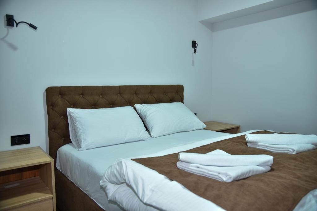 a bed with two white pillows on top of it at Apartmani COLOSSEUM in Bratunac