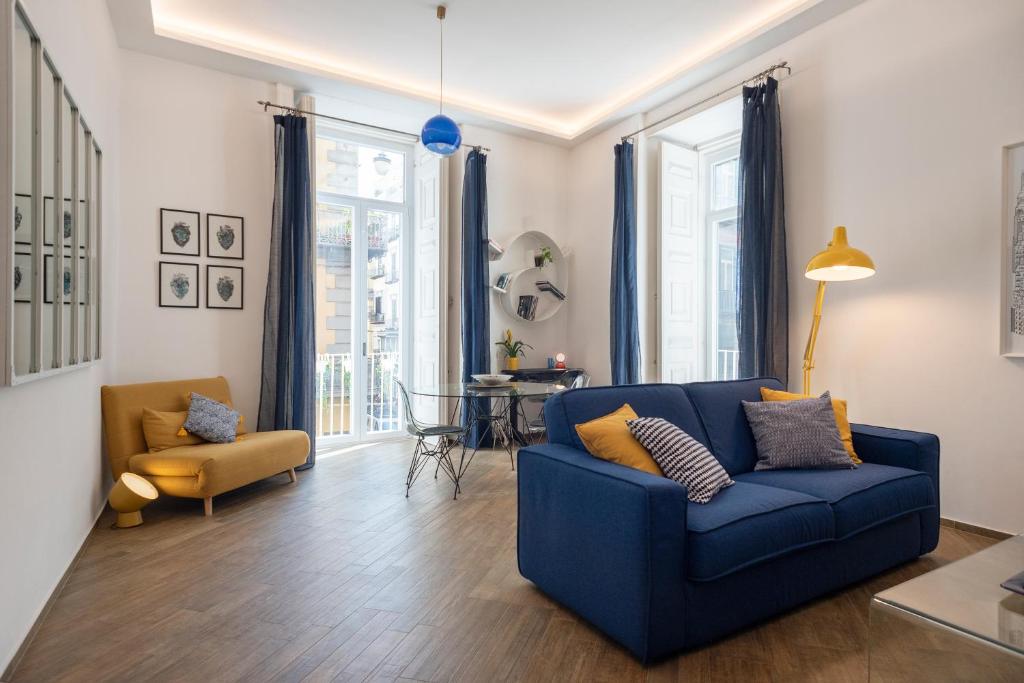 un soggiorno con divano blu e tavolo di La Casa Blu a Toledo di Alberto a Napoli