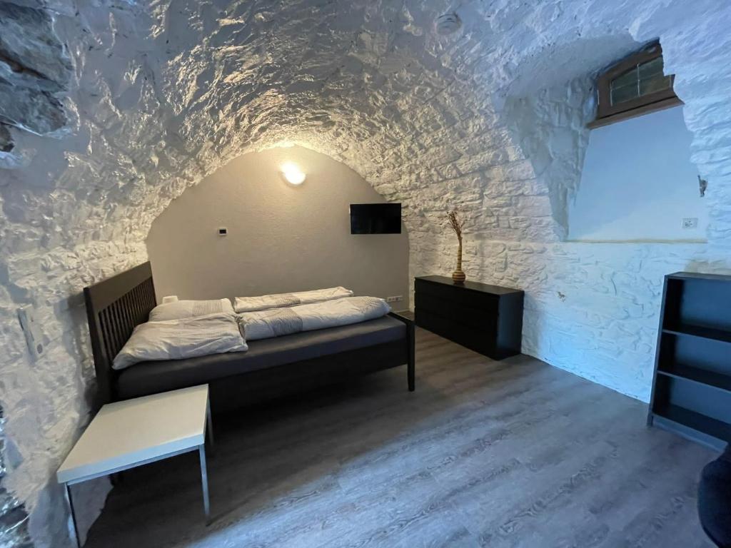 a bedroom with a bed in a stone wall at City Apartment Bad Säckingen mit Parkplatz in Bad Säckingen