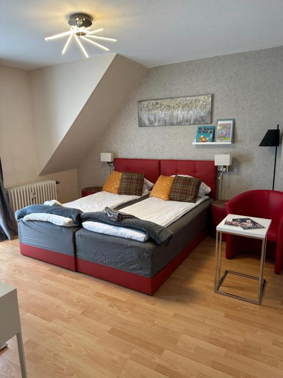 een slaapkamer met een bed met een rood hoofdeinde bij Diamanthaus 1 Koblenz in Koblenz