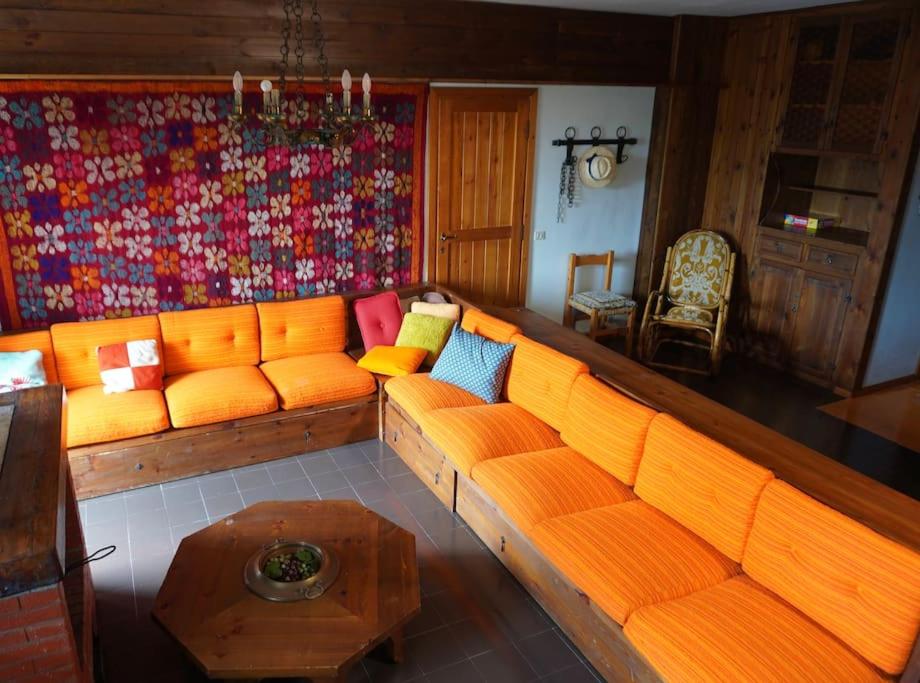 sala de estar con sofá naranja y mesa en Il Rifugio da Aldo - Rivisondoli en Rivisondoli