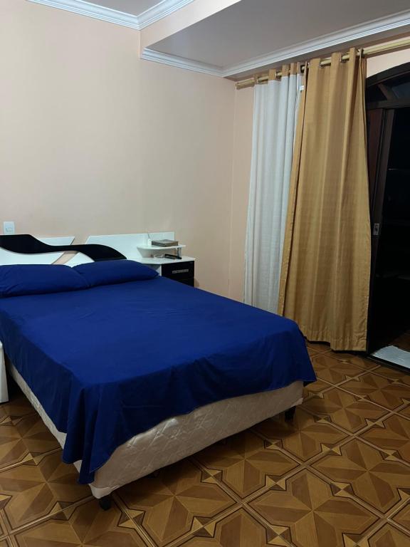 a bedroom with a blue bed in a room at Sobrado lindo em Itú a 5 minutos do Centro ! in Itu