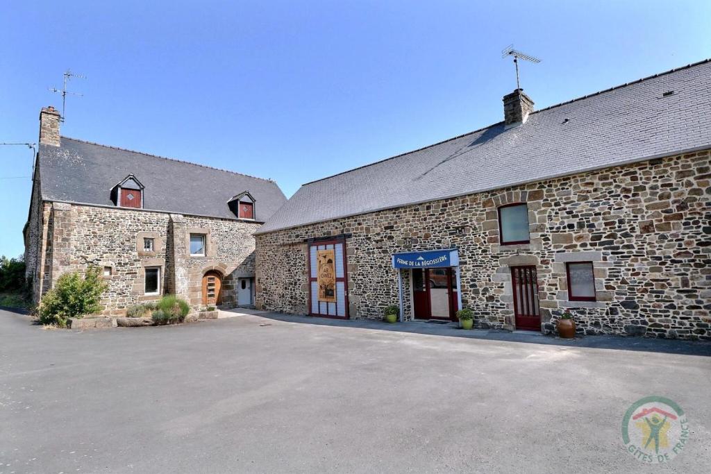 un edificio in mattoni con un parcheggio di fronte di La ferme de la begossiere a Roz-sur-Couesnon