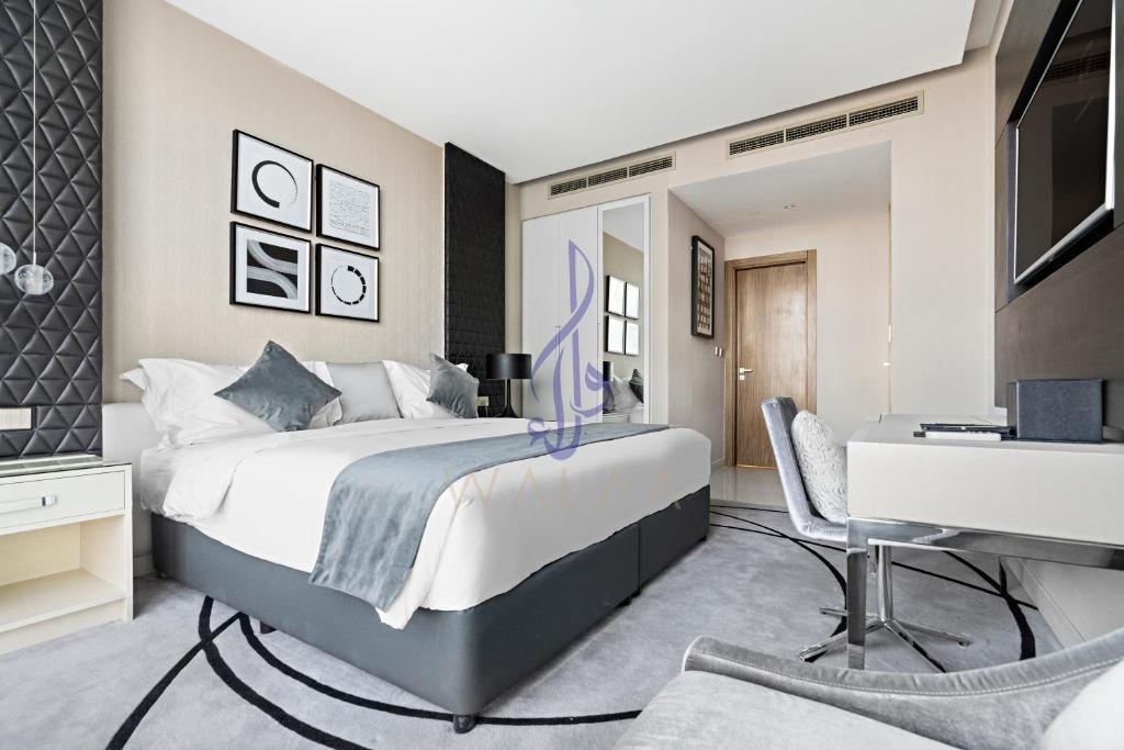 a bedroom with a large bed and a desk at Walaa Homes Luxury 2BR at DAMAC Esclusiva Tower Riyadh-3104 in Riyadh