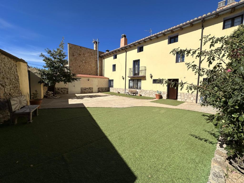 a courtyard of a building with a grass yard at Casa Rural La Quinta Del Poeta 