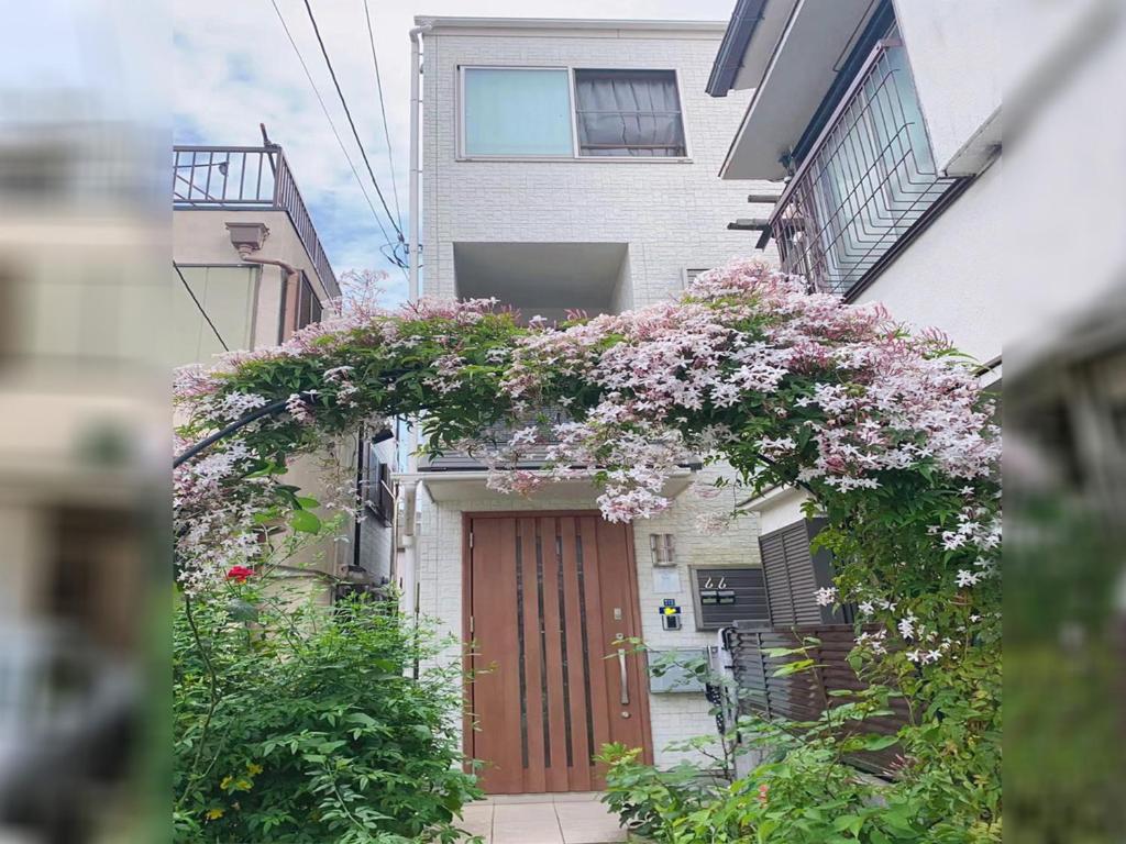 - un bâtiment avec une porte fleurie dans l'établissement 新規OPEN8割！1棟貸切・10名可能！秋葉原まで13分、新宿まで32分／スカイツリー近く, à Tokyo