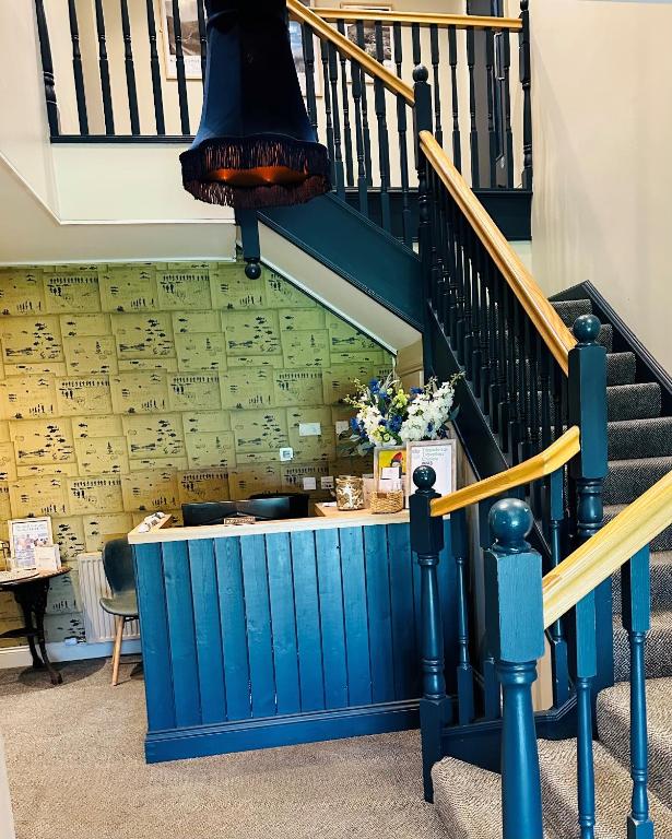 a staircase with a blue wall with music on it at Beach House Hotel in Seahouses