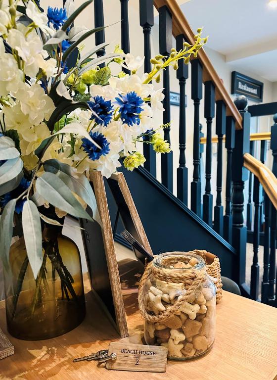 a vase with blue and white flowers on a table at Beach House Hotel in Seahouses
