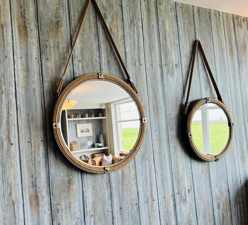 a mirror on a wall with two mirrors on it at Beach House Hotel in Seahouses