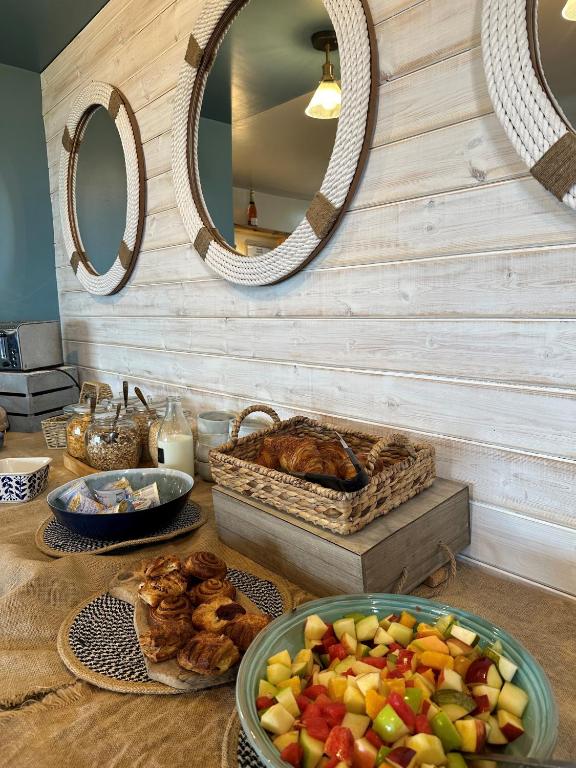 a table with a bowl of fruit and a basket of bread at Beach House Hotel in Seahouses