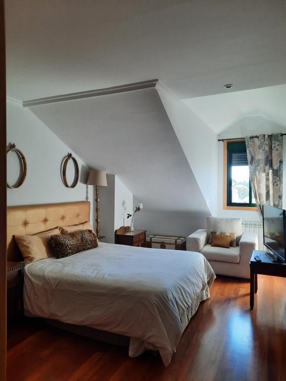 La CañizaにあるEl Ático de BaBauのベッドルーム(大型ベッド1台、ソファ付)