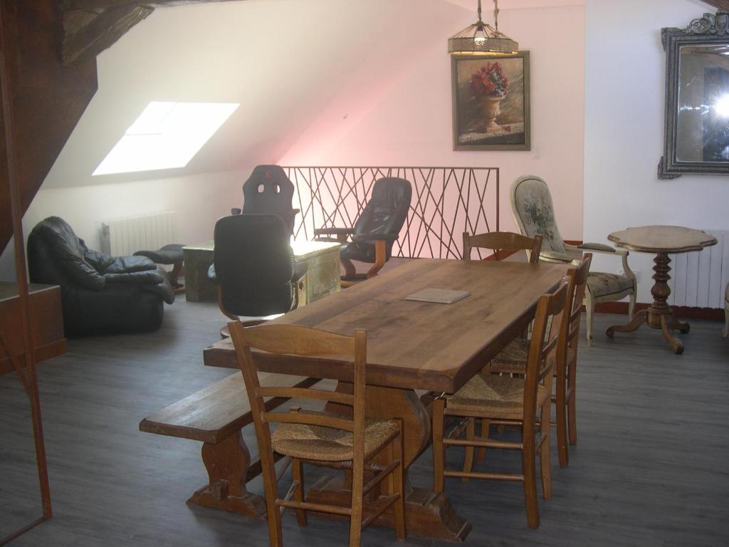 ein Esszimmer mit einem Holztisch und Stühlen in der Unterkunft la ruée vers l'art 