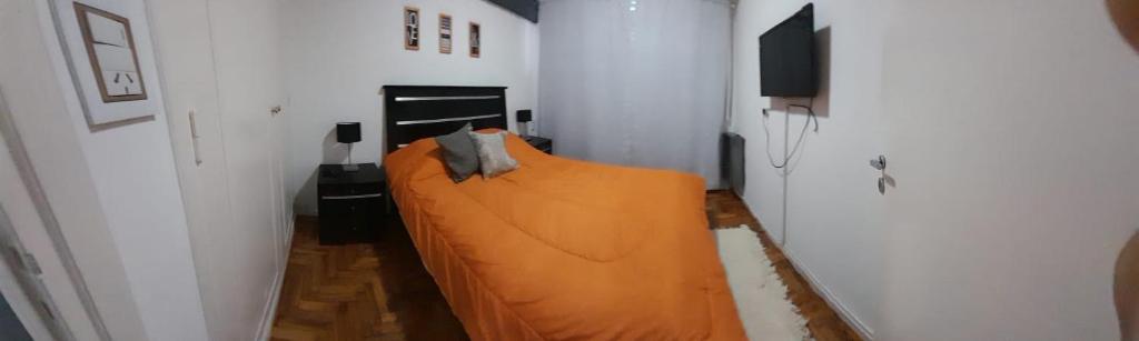a bedroom with a bed with an orange sheet at Jorge ll in Mar del Plata