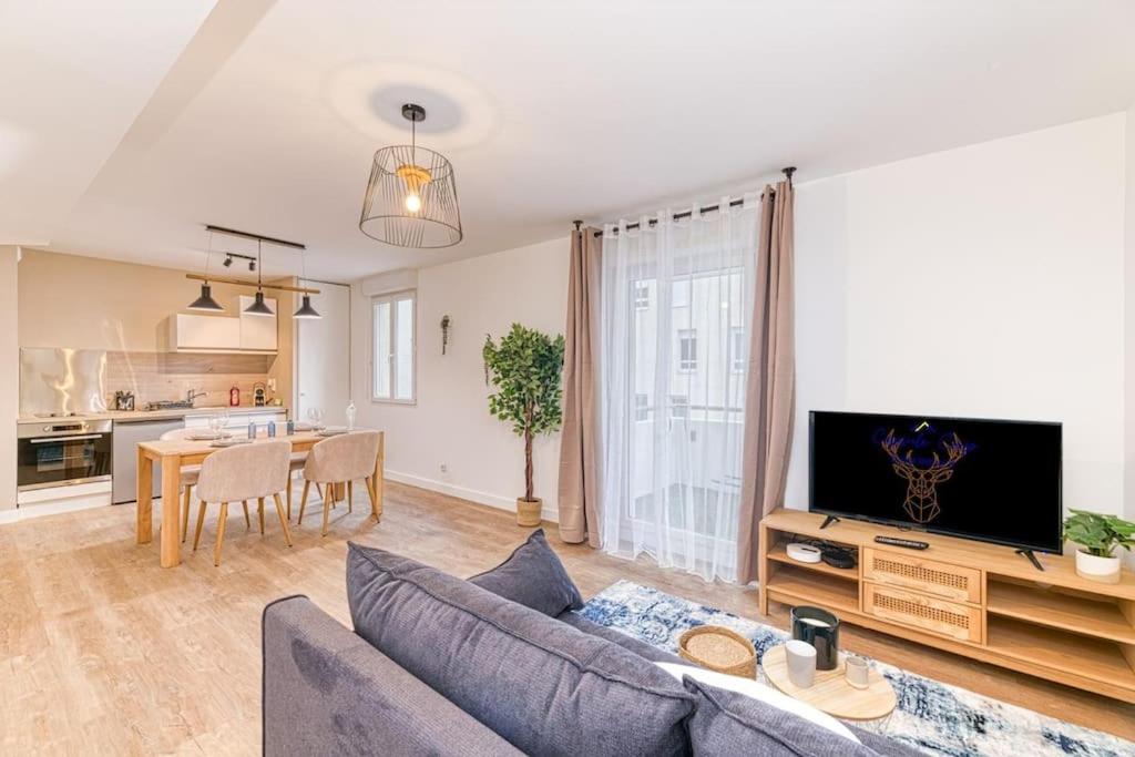 un salon avec un canapé bleu et une cuisine dans l'établissement Quartier Gare, 2 personnes, wifi fibre, balcon, à Grenoble