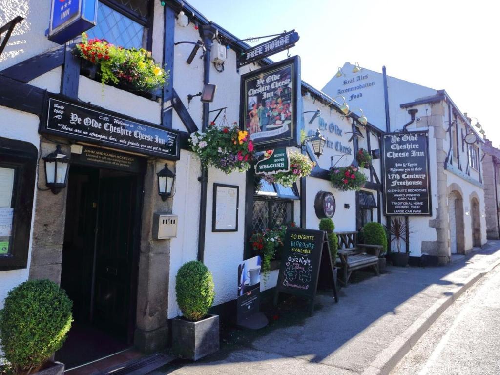 a building with signs on it on a street at Ye Olde Cheshire Cheese Inn in Castleton