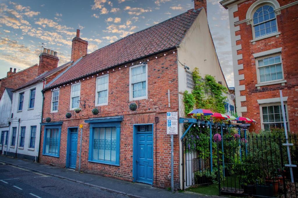 a brick house with blue doors on a street at The Secret Garden in Newark upon Trent