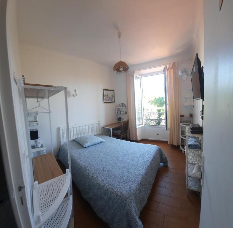 ein kleines Schlafzimmer mit einem Bett und einem Fenster in der Unterkunft GHIS Lotus in Cannes