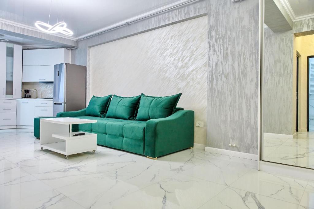 a living room with a green couch and a table at Apartamente by R S in Năvodari
