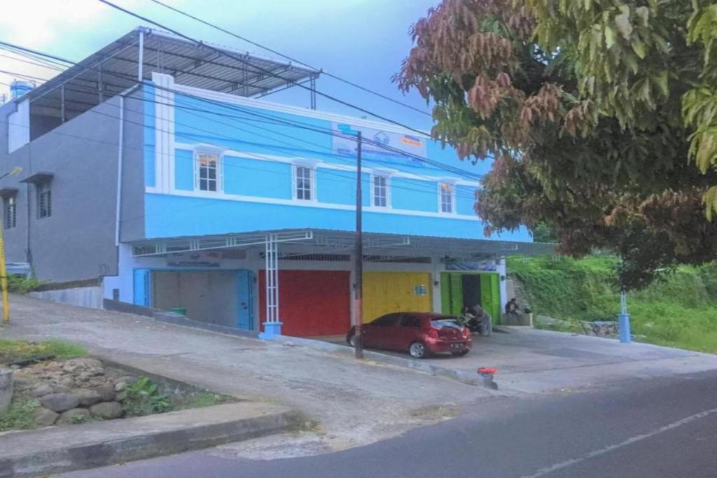 un edificio azul con un coche aparcado delante de él en OYO 93169 Bnb Homestay en Parepare