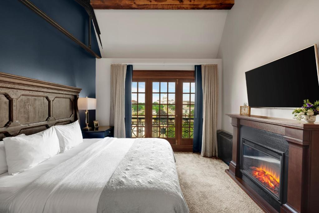a bedroom with a bed with a fireplace and a tv at Celeste of St Paul in Saint Paul