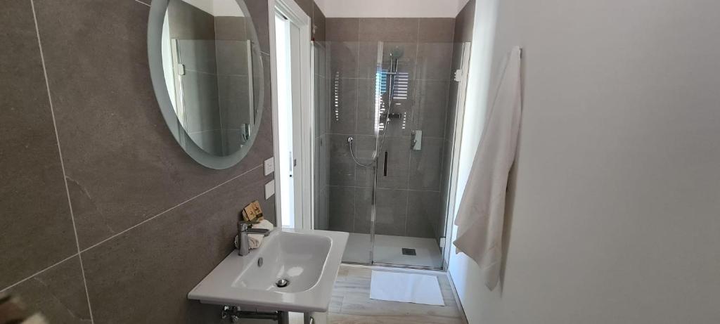 a bathroom with a sink and a shower with a mirror at ECO-HOUSE DA FRANCO in Civitanova Marche
