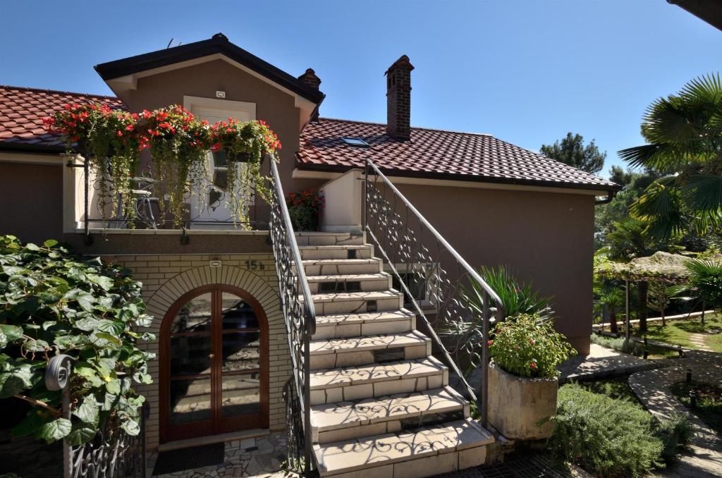 a staircase leading to a house with flowers on it at Apartments Viktoria in Lovran