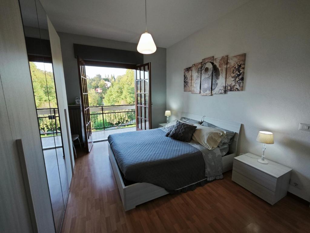 1 dormitorio con cama y ventana grande en Una finestra sul verde, en Sassello