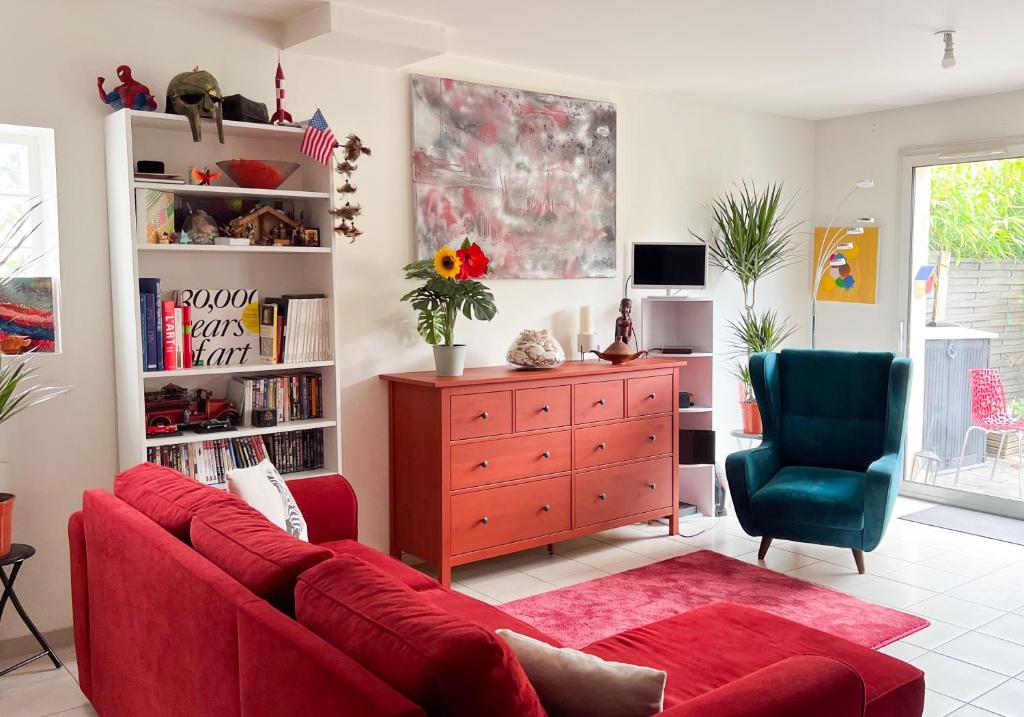 ein Wohnzimmer mit einem roten Sofa und einem Schreibtisch in der Unterkunft Charmante maison Proche centre-ville in Rambouillet