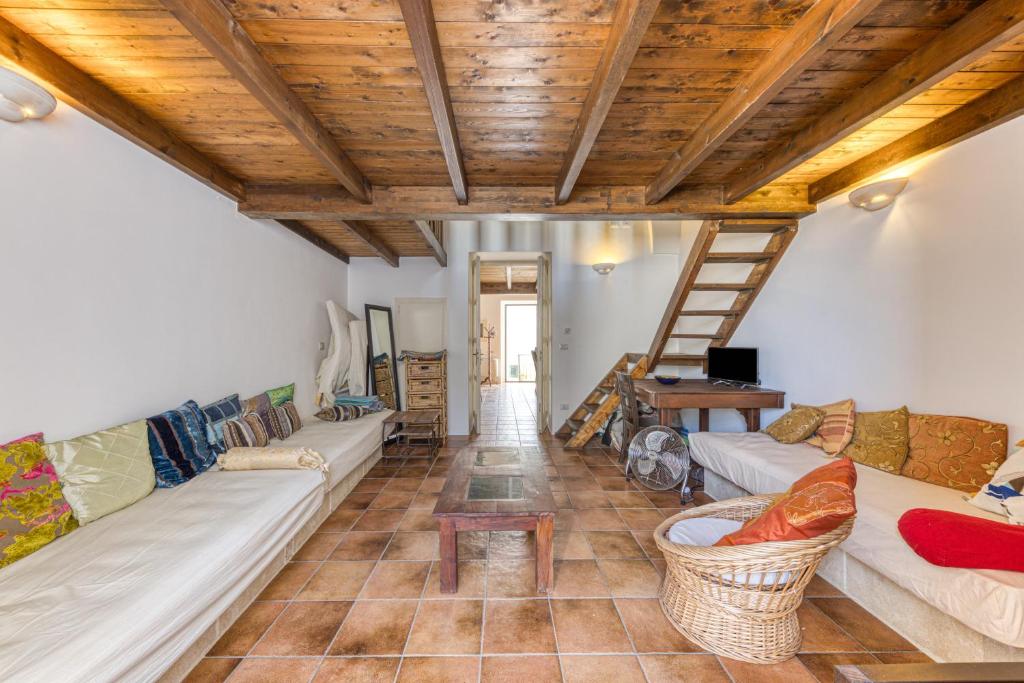 een woonkamer met banken en een houten plafond bij Antica dimora nel capo di Leuca in Alessano
