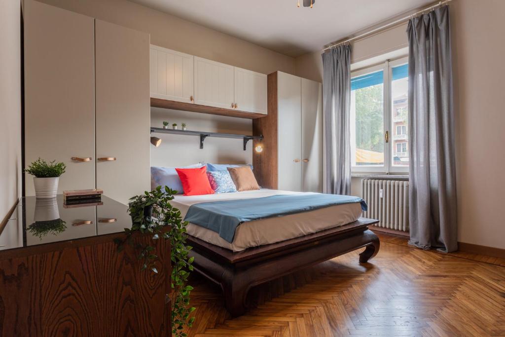 sypialnia z łóżkiem z niebieskimi i czerwonymi poduszkami w obiekcie Casa Thermignon by Wonderful Italy w Turynie