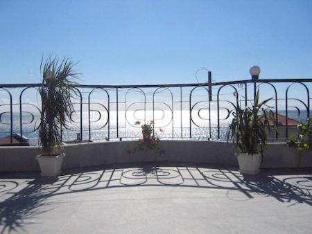 a balcony with three potted plants on a fence at Lazur Hotel in Ravda